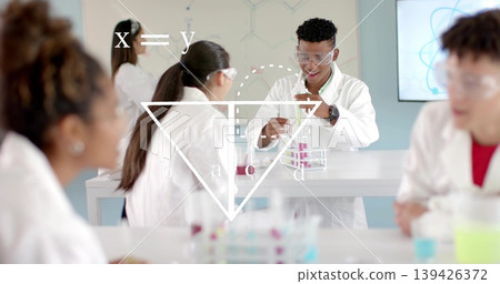 Transferring liquids students in lab coats and goggles at school lab, using pipettes and test tubes Transferring liquids students in lab coats and goggles at school lab, using pipettes and test tubes 139426372