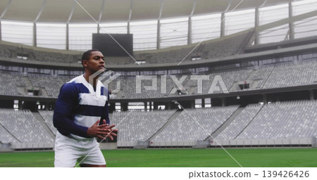 Standing athlete wearing striped jersey white shorts on grass field with scoreboard, copy space Standing athlete wearing striped jersey white shorts on grass field with scoreboard, copy space 139426426
