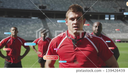 Standing front-center athlete wearing red jersey and black shorts on grass pitch, with digital tags Standing front-center athlete wearing red jersey and black shorts on grass pitch, with digital tags 139426439