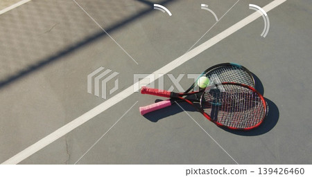 Showing crossed tennis rackets resting on outdoor hard court with tennis ball, copy space Showing crossed tennis rackets resting on outdoor hard court with tennis ball, copy space 139426460