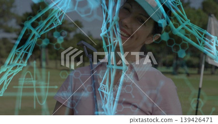 Smiling mature woman wearing golf visor gripping putter on fairway, with molecular hexagon graphics Smiling mature woman wearing golf visor gripping putter on fairway, with molecular hexagon graphics 139426471