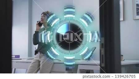 Leaning office worker talking on smartphone at office desk with purple binder, with holographic UI Leaning office worker talking on smartphone at office desk with purple binder, with holographic UI 139426705