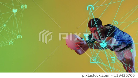 Lunging male athlete reaching to catch white ball in studio, with neon network graphics, copy space Lunging male athlete reaching to catch white ball in studio, with neon network graphics, copy space 139426706