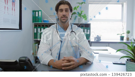 Mid adult doctor wearing coat reviewing paperwork, smartphone in consultation room with stethoscope Mid adult doctor wearing coat reviewing paperwork, smartphone in consultation room with stethoscope 139426723