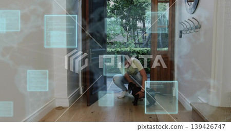 Greeting kneeling Asian man welcoming small black puppy at open front doors, with digital UI panels Greeting kneeling Asian man welcoming small black puppy at open front doors, with digital UI panels 139426747