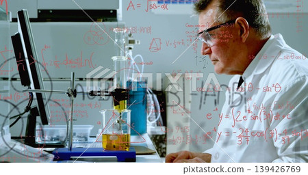 Analyzing chemist wearing lab coat studying separation apparatus with monitor in lab, copy space Analyzing chemist wearing lab coat studying separation apparatus with monitor in lab, copy space 139426769