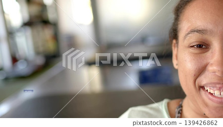 Smiling woman sitting by long tables in communal room, wearing light top and chain, copy space Smiling woman sitting by long tables in communal room, wearing light top and chain, copy space 139426862