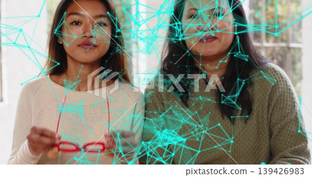Holding red glasses, mother and daughter sitting at home, wearing knit sweaters, turquoise overlay Holding red glasses, mother and daughter sitting at home, wearing knit sweaters, turquoise overlay 139426983