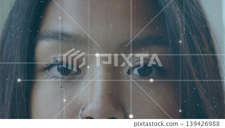 Gazing Chinese woman filling frame in studio close-up, showing hoop nose ring and digital grid Gazing Chinese woman filling frame in studio close-up, showing hoop nose ring and digital grid 139426988