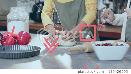 Kneading adult Asian woman in green apron shaping dough on kitchen countertop, with flour jar Kneading adult Asian woman in green apron shaping dough on kitchen countertop, with flour jar 139426993