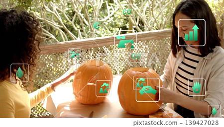 Carving two women carving pumpkins on porch in yellow top, striped shirt with knives, overlays Carving two women carving pumpkins on porch in yellow top, striped shirt with knives, overlays 139427028