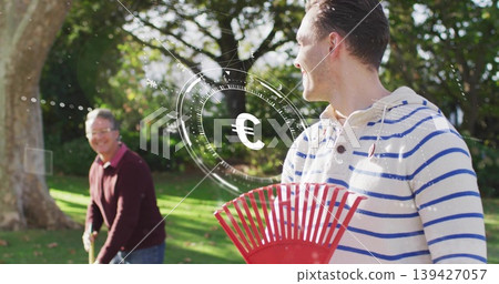 Raking man in white hoodie blue stripes in backyard, maroon sweater holding red rake, Euro HUD Raking man in white hoodie blue stripes in backyard, maroon sweater holding red rake, Euro HUD 139427057