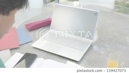 Displaying open white laptop showing blank screen on round glass table, with phone and notebooks Displaying open white laptop showing blank screen on round glass table, with phone and notebooks 139427073