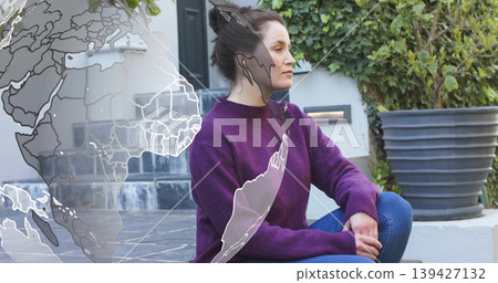 Sitting woman wearing purple sweater and jeans on tiled steps, with globe overlay, planter and ivy Sitting woman wearing purple sweater and jeans on tiled steps, with globe overlay, planter and ivy 139427132