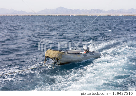 Serene ocean sails with inflatable dinghy and mountain views Serene ocean sails with inflatable dinghy and mountain views 139427510