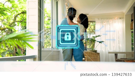 Embracing couple wearing light-blue sweater and white top standing at home, digital padlock overlay Embracing couple wearing light-blue sweater and white top standing at home, digital padlock overlay 139427633