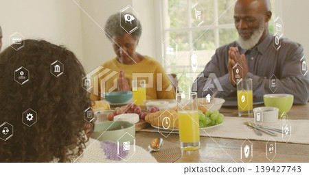 Praying extended family clasping hands at dining table, wearing sweaters, with platter and overlay Praying extended family clasping hands at dining table, wearing sweaters, with platter and overlay 139427743