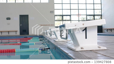 Framing white starting block 1 occupying right pool edge, textured top and metal grips, copy space Framing white starting block 1 occupying right pool edge, textured top and metal grips, copy space 139427808