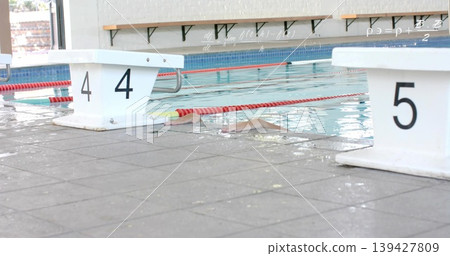 Swimming woman wearing pink cap, swimsuit in pool lane with red lane rope and blocks 4-5 Swimming woman wearing pink cap, swimsuit in pool lane with red lane rope and blocks 4-5 139427809