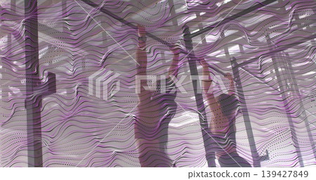 Practicing two women doing pole moves in studio with purple overlay, chrome poles, in sports bras Practicing two women doing pole moves in studio with purple overlay, chrome poles, in sports bras 139427849
