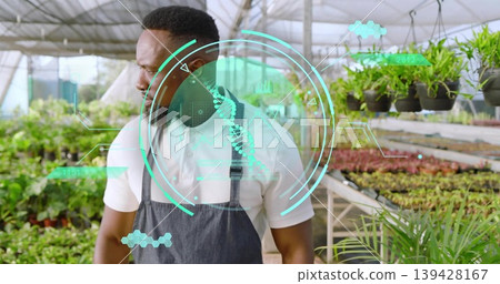 Inspecting greenhouse worker wearing white polo gray apron examining potted plants, showing DNA HUD Inspecting greenhouse worker wearing white polo gray apron examining potted plants, showing DNA HUD 139428167