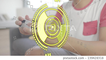 Gripping adult Asian male wearing red-and-white tee using white-black gamepad on sofa, yellow HUD Gripping adult Asian male wearing red-and-white tee using white-black gamepad on sofa, yellow HUD 139428318