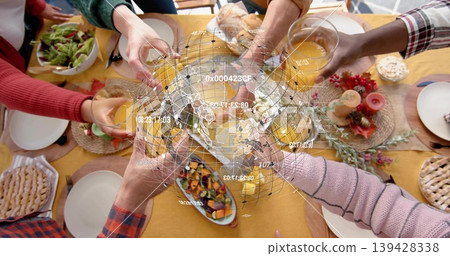 Clinking six hands with bright sleeves holding orange juice at dining table with holo globe Clinking six hands with bright sleeves holding orange juice at dining table with holo globe 139428338