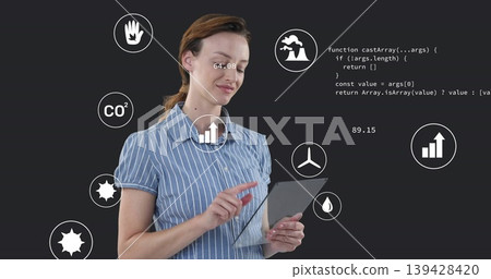 Tapping woman wearing striped shirt using tablet in studio, showing data icons and code Tapping woman wearing striped shirt using tablet in studio, showing data icons and code 139428420