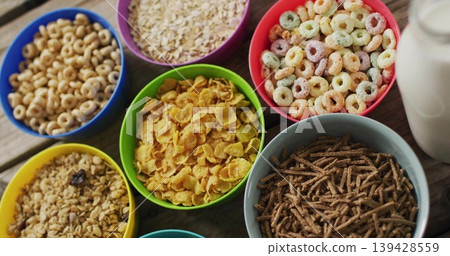 Featuring green cornflake bowl sitting on rustic wooden tabletop, with cereal bowls and milk bottle Featuring green cornflake bowl sitting on rustic wooden tabletop, with cereal bowls and milk bottle 139428559