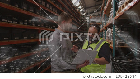 Holding tablet, two men wearing dress shirt and safety vest inspecting labeled bins in warehouse Holding tablet, two men wearing dress shirt and safety vest inspecting labeled bins in warehouse 139428584