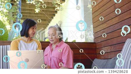 Pointing daughter and mother viewing laptop on porch bench wearing pink shirt raglan, pergola icons Pointing daughter and mother viewing laptop on porch bench wearing pink shirt raglan, pergola icons 139428628