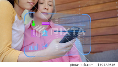 Leaning mother and adult daughter studying smartphone screen with blue AR financial overlay at home Leaning mother and adult daughter studying smartphone screen with blue AR financial overlay at home 139428636