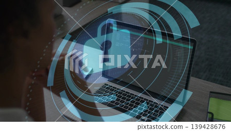 Reviewing woman in dark top viewing laptop code at office desk with smartphone, showing padlock HUD Reviewing woman in dark top viewing laptop code at office desk with smartphone, showing padlock HUD 139428676