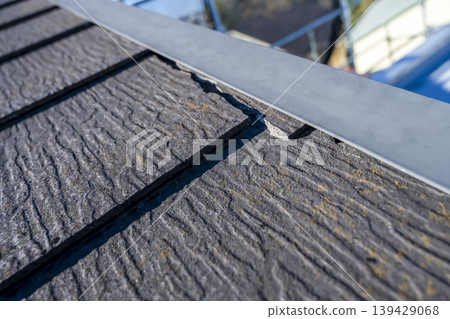An old slate roof that has cracked due to age-related deterioration. An old slate roof that has cracked due to age-related deterioration. 139429068