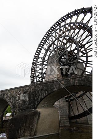 A giant wooden waterwheel stands tall at the Obaachan-ichi Yamaoka roadside station. A giant wooden waterwheel stands tall at the Obaachan-ichi Yamaoka roadside station. 139429427