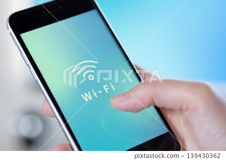 手中握著的智慧型手機螢幕上顯示著免費Wi-Fi圖示。 （原圖） 139430362