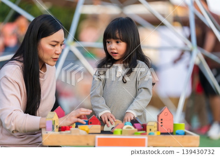 mother and preschool child girl playing with wooden toy block at outdoor mother and preschool child girl playing with wooden toy block at outdoor 139430732