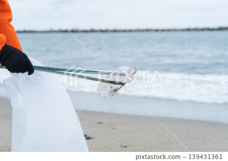 People picking up trash at the beach People picking up trash at the beach 139431361