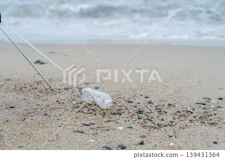 People picking up trash at the beach People picking up trash at the beach 139431364
