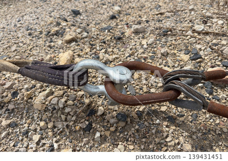 Tow strap shackle chain on gravel. Tow strap shackle chain on gravel. 139431451