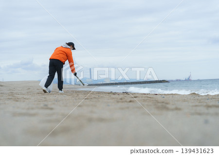 人們在海灘上撿垃圾 139431623