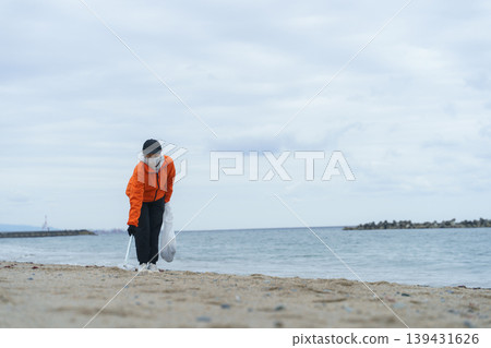 People picking up trash on the beach People picking up trash on the beach 139431626