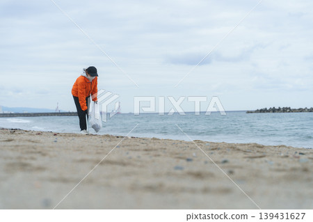 People picking up trash on the beach People picking up trash on the beach 139431627