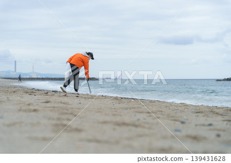 People picking up trash on the beach People picking up trash on the beach 139431628