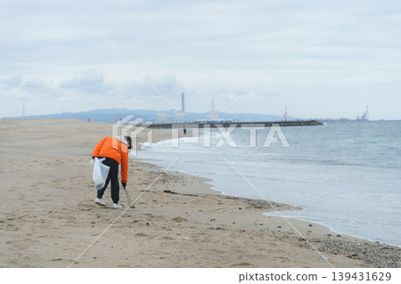 人們在海灘上撿垃圾 139431629