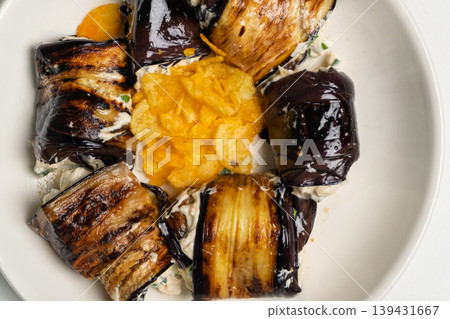 Grilled eggplant rolls with creamy filling and potato chips on a plate Grilled eggplant rolls with creamy filling and potato chips on a plate 139431667