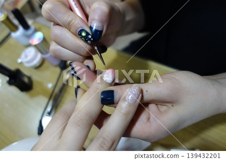 Nail Artist Applying Glitter Detail to Client's Nail Nail Artist Applying Glitter Detail to Client's Nail 139432201