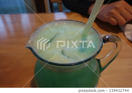 Green Smoothie in Glass Pitcher with Straw 139432744