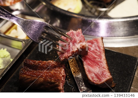 Fork Lifting Medium-Rare Steak Slice with Sliced Meat Fork Lifting Medium-Rare Steak Slice with Sliced Meat 139433146