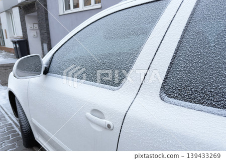 Winter's icy touch blankets a car, its windows veiled in a delicate frost. The world outside blurs behind a crystalline curtain of cold beauty. Winter's icy touch blankets a car, its windows veiled in a delicate frost. The world outside blurs behind a crystalline curtain of cold beauty. 139433269